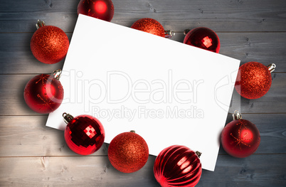 Composite image of red christmas baubles surrounding white page Composite image of red christmas baubles surrounding white page
