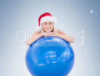 Festive fit blonde leaning on exercise ball