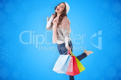 Composite image of excited brunette posing with shopping bag