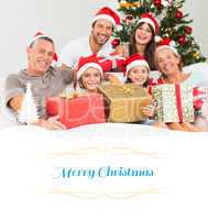 Composite image of happy family at christmas holding gifts