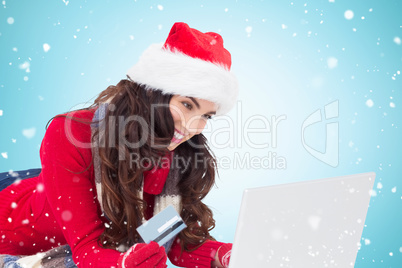 Composite image of happy brunette shopping online with laptop