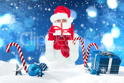 Composite image of festive woman holding gift