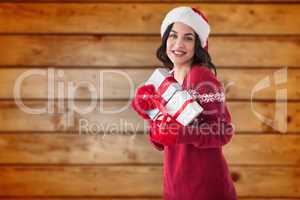 Composite image of cheerful brunette holding christmas presents