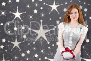 Composite image of pretty redhead offering a gift