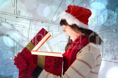 Composite image of festive brunette opening a glowing christmas