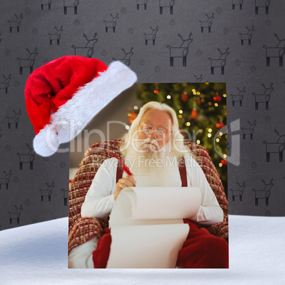 Composite image of relaxed santa writing list with a quill