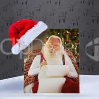 Composite image of relaxed santa writing list with a quill