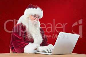 Composite image of santa surfs on the internet