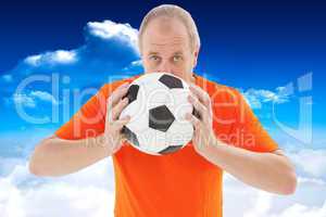 Composite image of nervous football fan holding ball