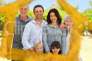 Composite image of family standing in the park