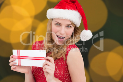 Composite image of woman smiling with present in hands