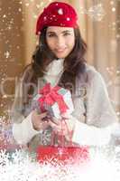 Composite image of smiling brunette holding gift and shopping bags