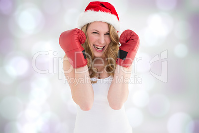Composite image of blonde woman wearing boxing gloves smiling at