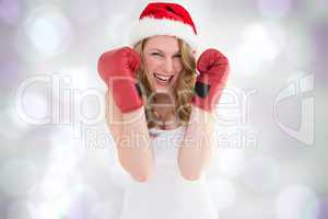 Composite image of blonde woman wearing boxing gloves smiling at