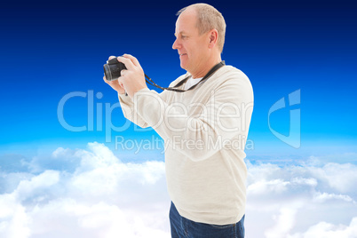 Composite image of happy mature man taking a picture