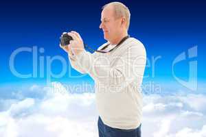 Composite image of happy mature man taking a picture