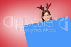 Composite image of festive little girl showing card