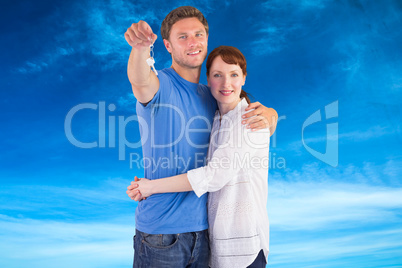 Composite image of couple holding keys to home