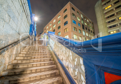Stairs of Tower Bridge at night with surrounding buildings, Lond