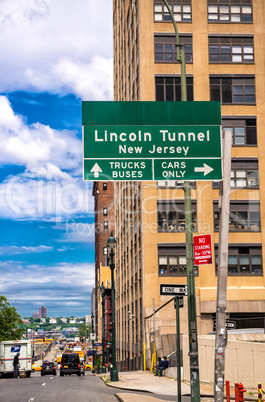 Lincoln Tunnel signage in Manhattan with city skyline