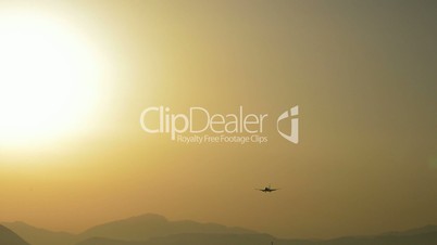 Airplane flying at low altitude at sunset