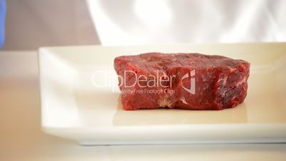 Hands of chef or professional chef cutting red veal or beef