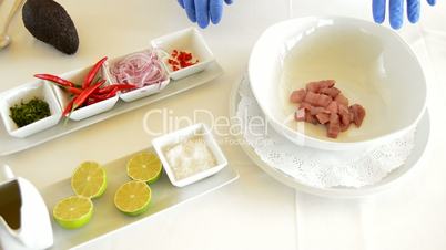Hands of professional chef adding ingredients to make ceviche