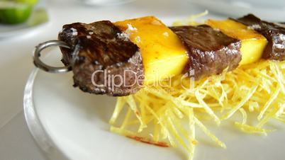 Skewer of mango fruit and meat of cow or beef at grill panoramic