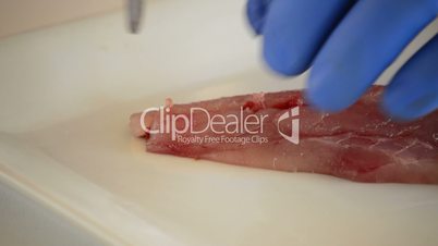 Professional chef hands cutting a fish fillet into cubes