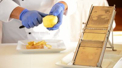 Professional chef hands cutting potatoes with