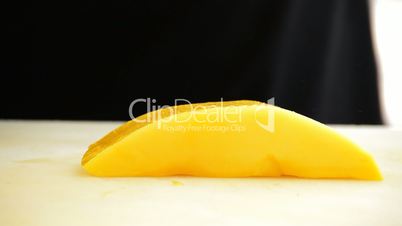 Hands of chef or professional chef cutting a mango into dices