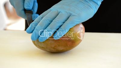 Professional chef hands cutting a mango in half