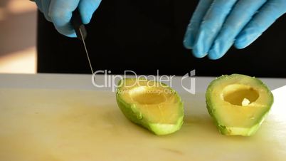 Professional chef hands cutting an avocado sliced