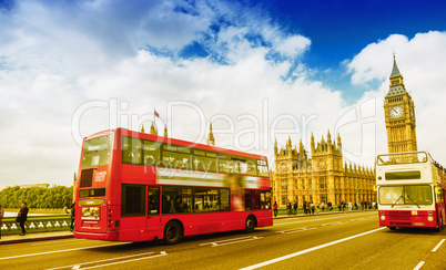 Two red buses crossing Westminter Bridge on a sunny day in Londo