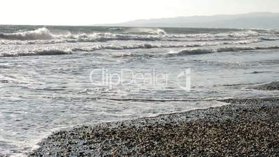 Rough waves on the Mediterranean seashore at sunset