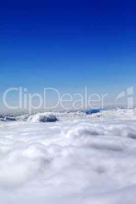 Mountains under clouds and clear blue sky