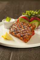 Grilled fish tikka served on a plate with salad and tarter sauce