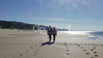 Happy Middle-aged Couple Walking on Ocean Sandy Beach