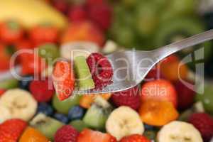 Obstsalat essen mit Früchte auf Gabel mit Erdbeere, Kiwi und Hi