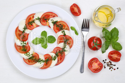 Salat Caprese mit Tomaten und Mozzarella von oben auf Holzbrett