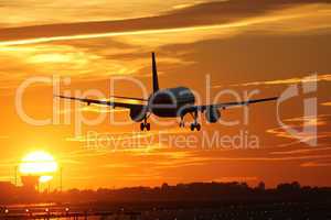 Flugzeug beim Landen auf Flughafen mit Sonnenuntergang