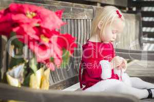 Adorable Little Girl Sitting On Bench with Her Candy Cane