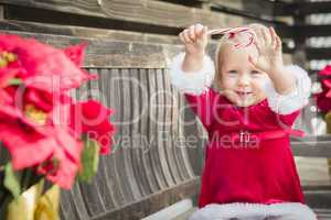 Adorable Little Girl Sitting On Bench with Her Candy Cane