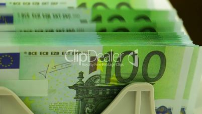 Banknote Counter and Stack of 100 Euro