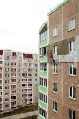 specialist carring out warming of many-storied building's wall