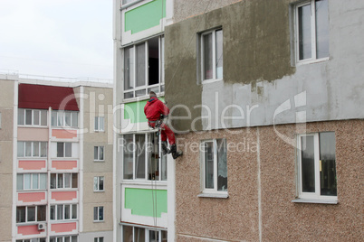 specialist carring out warming of many-storied building's wall