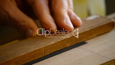 Close up, hands of craftsman cutting