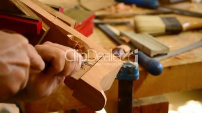 Luthier with chisel working in wood