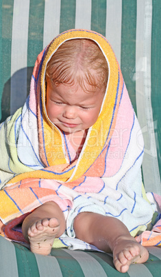 Baby in colored towel crying outdoor