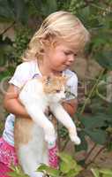 Cute little girl holding a red cat